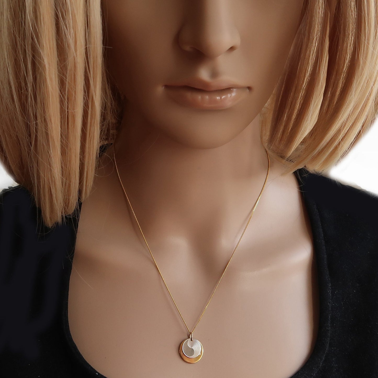 Bicolor Yin Yang Kette, getragen am Hals einer Frau.