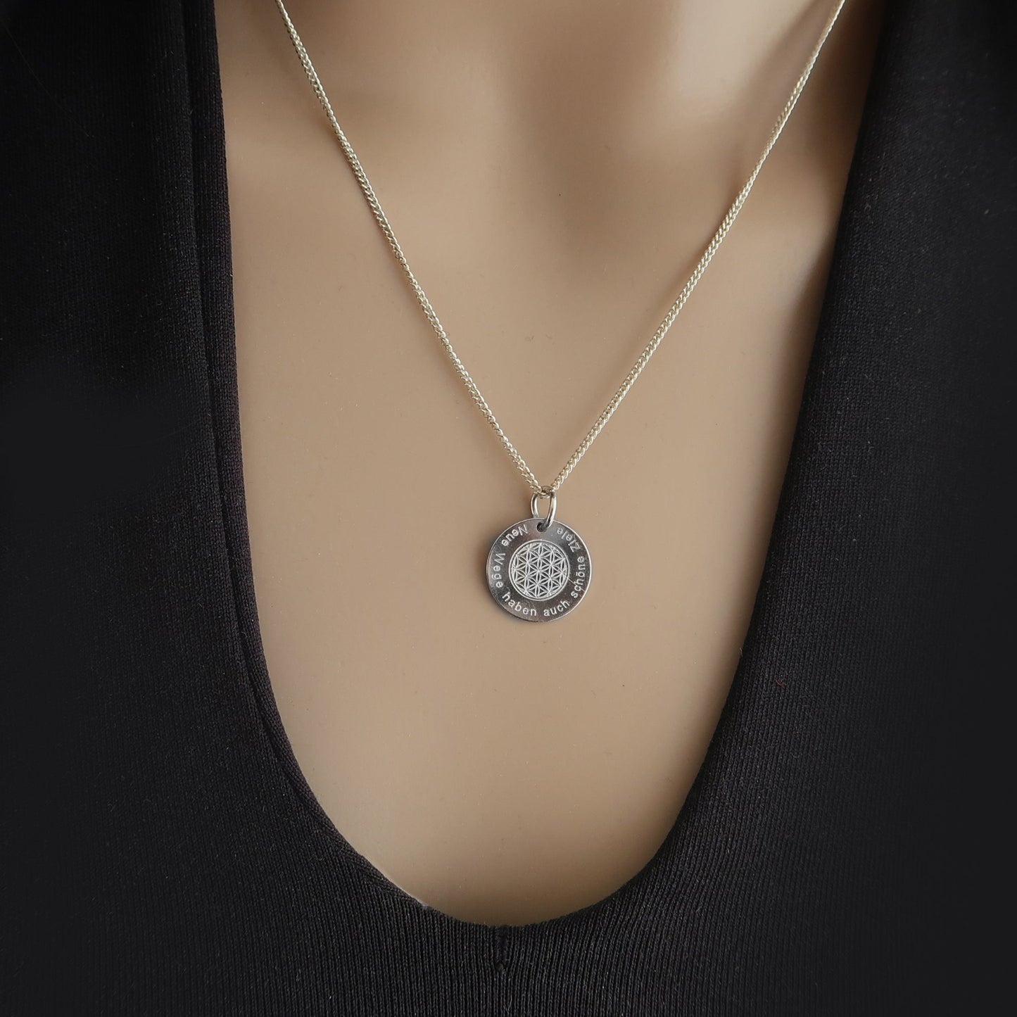 Nahaufnahme einer Frau mit Silberkette, Anhänger Blume des Lebens,