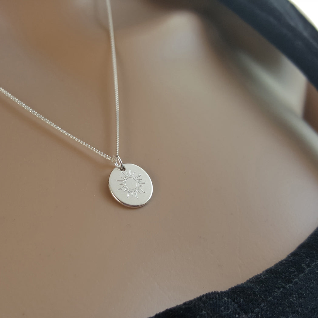 Silberkette mit Sonne auf dem Hals – Nahaufnahme