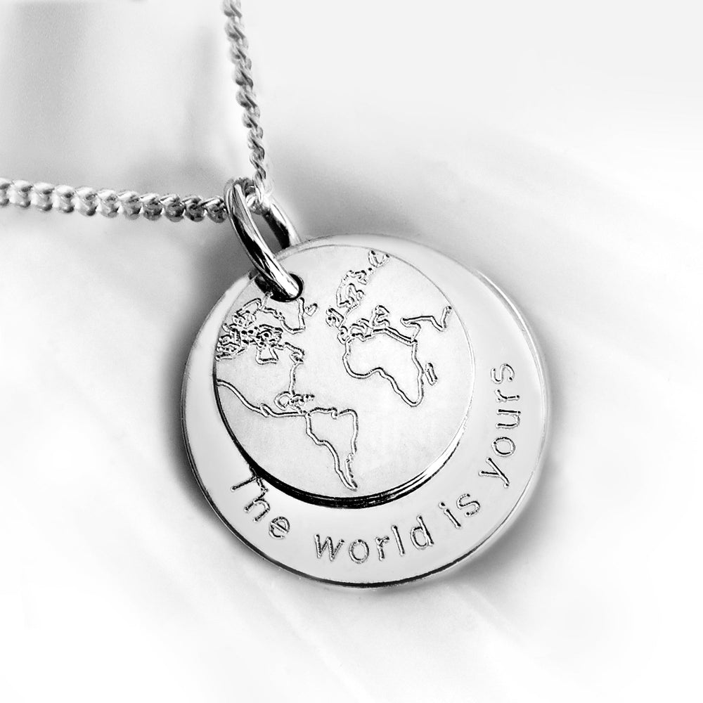 925 Silber Kette mit Anhänger-Duo. Kleiner Anhänger zeigt Weltkarte, größerer Anhänger mit Gravur am Rand.