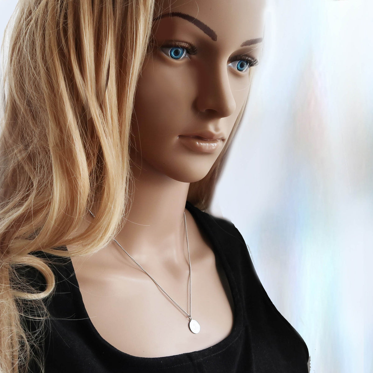 Junge Frau trägt eine Kette mit Ankeranhänger