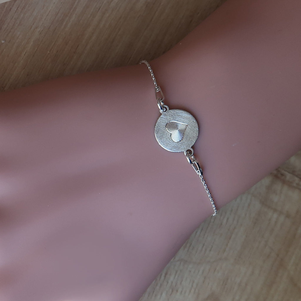 Handgefertigtes Silberarmband mit Herzmotiv am Handgelenk