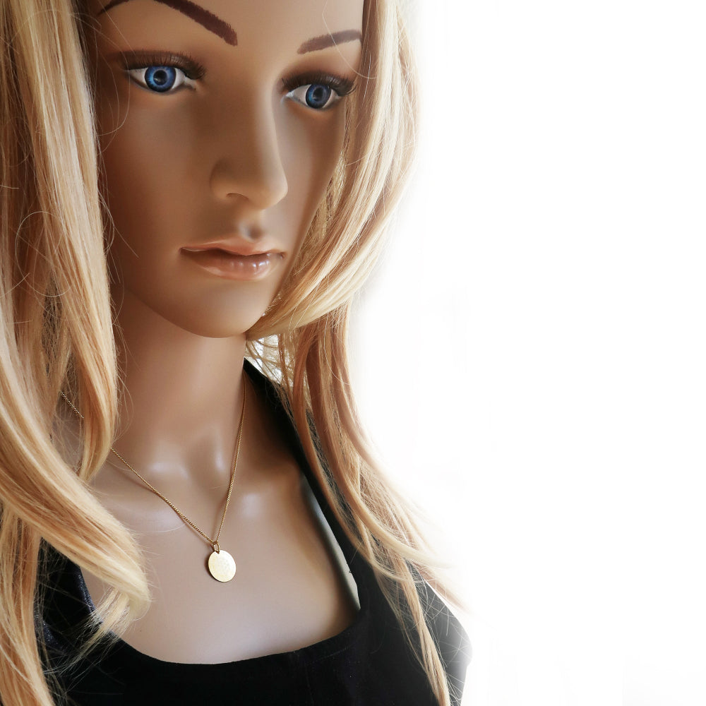 Eine Frau trägt vergoldete Kette mit Blume des Lebens und Gravur der Kindernamen