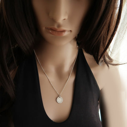 Eine Frau trägt runden Anhänger