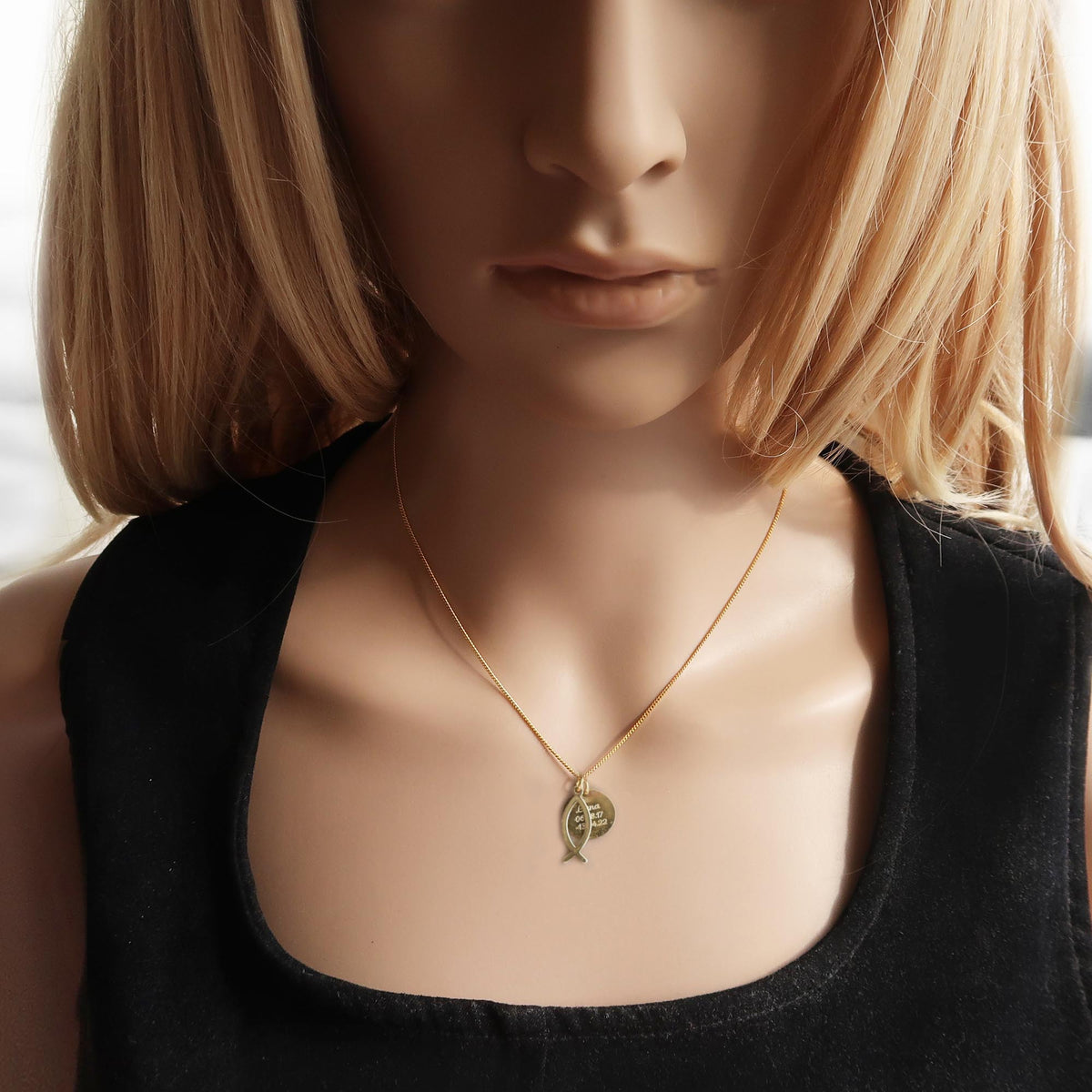 Eine Frau trägt eine filigrane christliche Kette mit zwei Anhängern aus vergoldetem 925 Silber