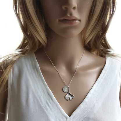 Junge Fau trägt eine Kette mit Gingkoanhänger und Gravurplatte