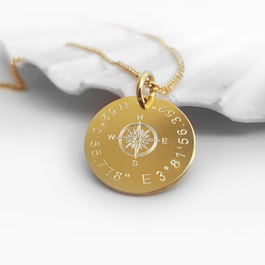 Vergoldete Damen-Halskette mit einem Kompass-Anhänger, personalisiert durch Ihre individuelle Gravur. Um den Kompass herum können entweder die Koordinaten Ihres Lieblingsortes oder eine persönliche Botschaft eingraviert werden.