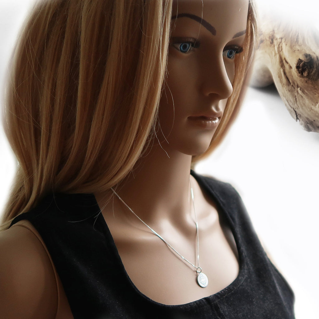 junge Frau trägt eine Kompass Kette 