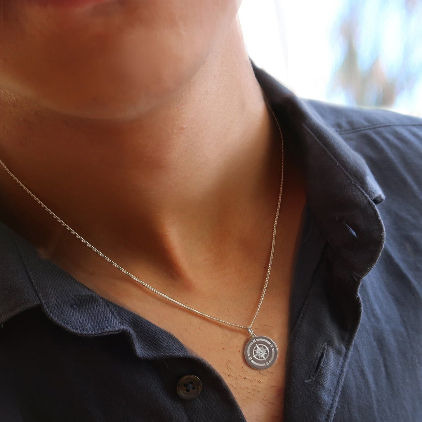 Mann trägt eine Kompasskette