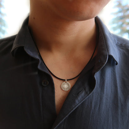 Lederbandkette mit Kompass-Anhänger, getragen von einem Mann.