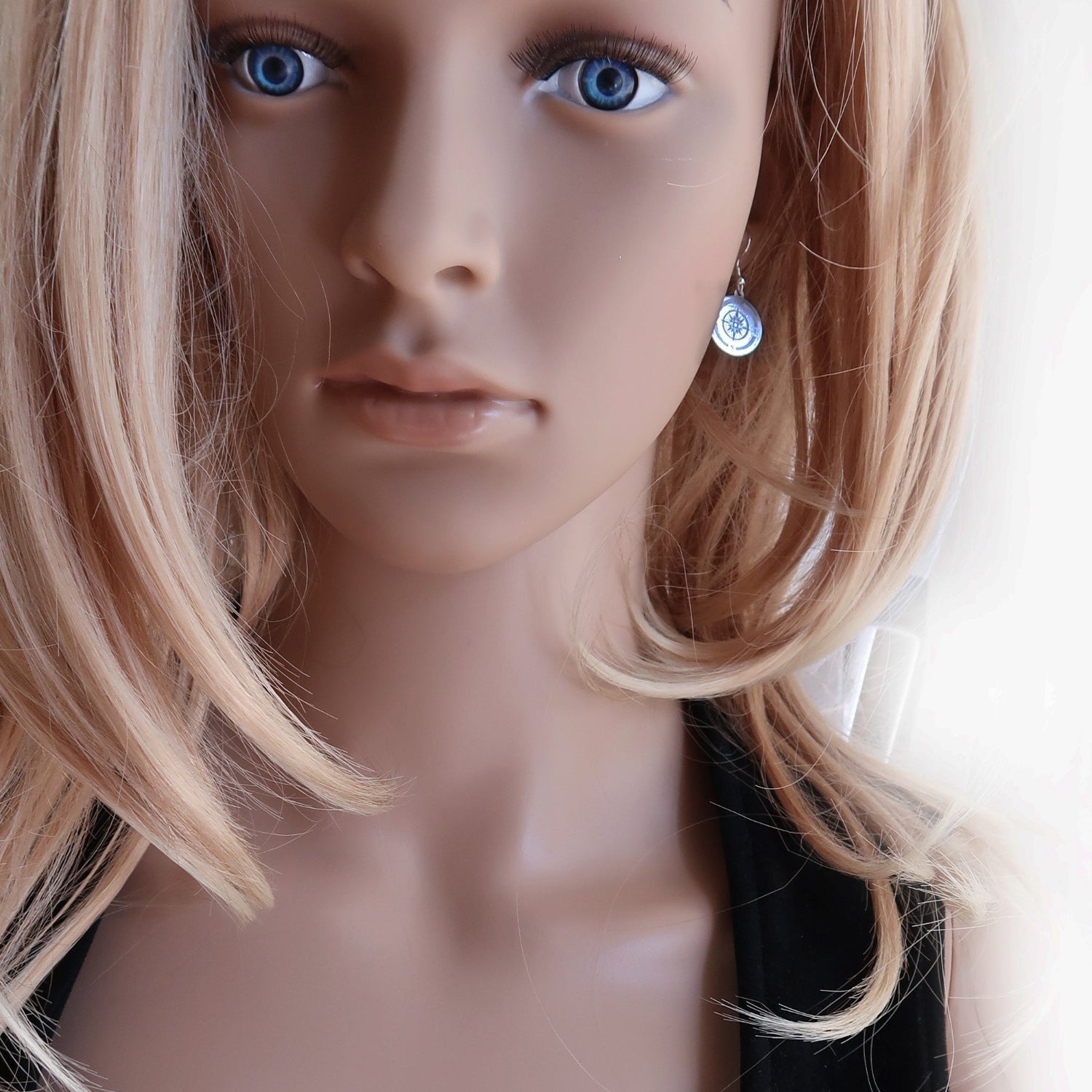 Eine Frau trägt Kompass Ohrringe aus 925er Sterlingsilber