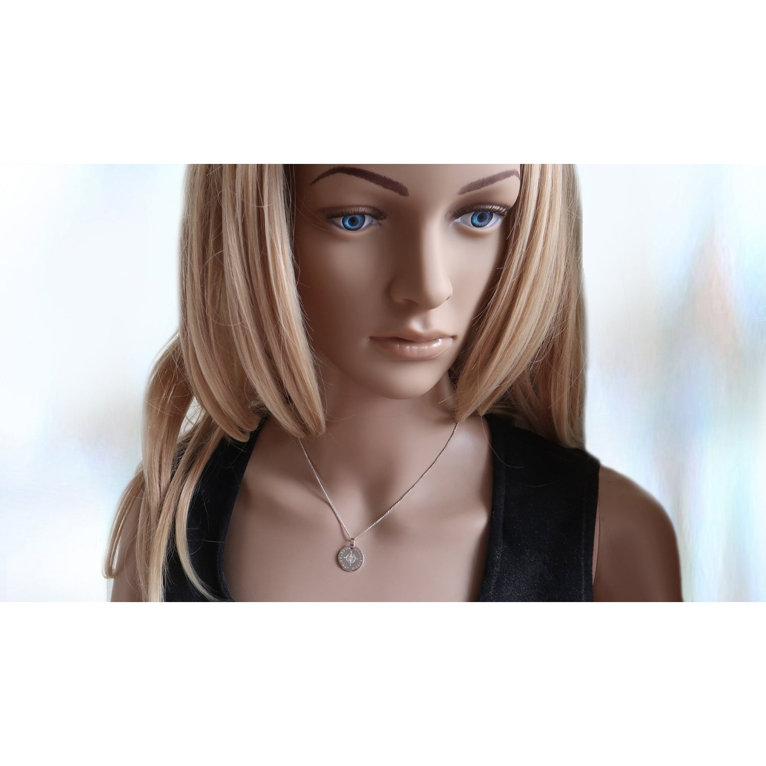 Silberkette mit Kompass Anhänger, getragen von einer Frau.