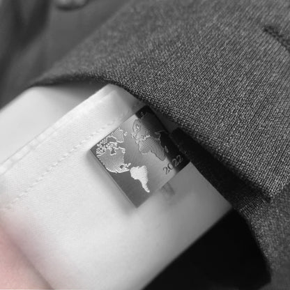 Ein Mann trägt Manschettenknöpfe mit Weltkartenmotiv