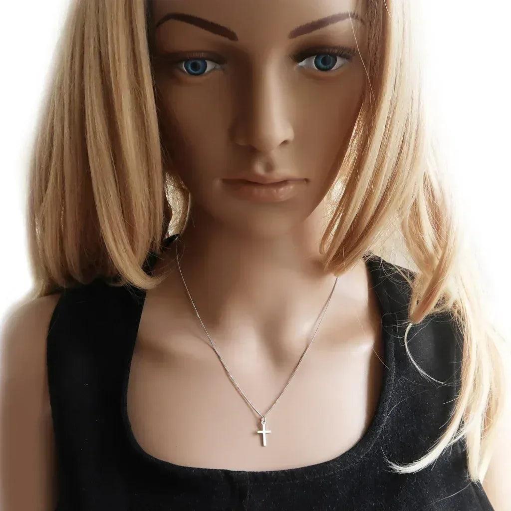Eine junge Dame trägt eine minimalistische Kreuzkette aus 925 Silber