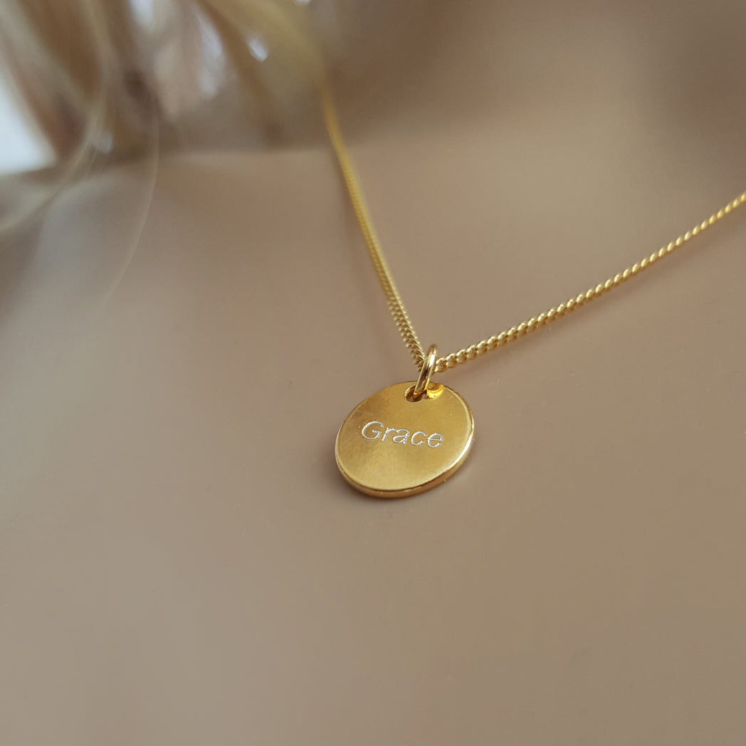 Nahaufnahme einer Kette mit Namensanhänger.