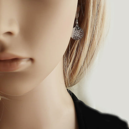 Eine Frau trägt Ohrringe mit Schmetterlingsmotiv.