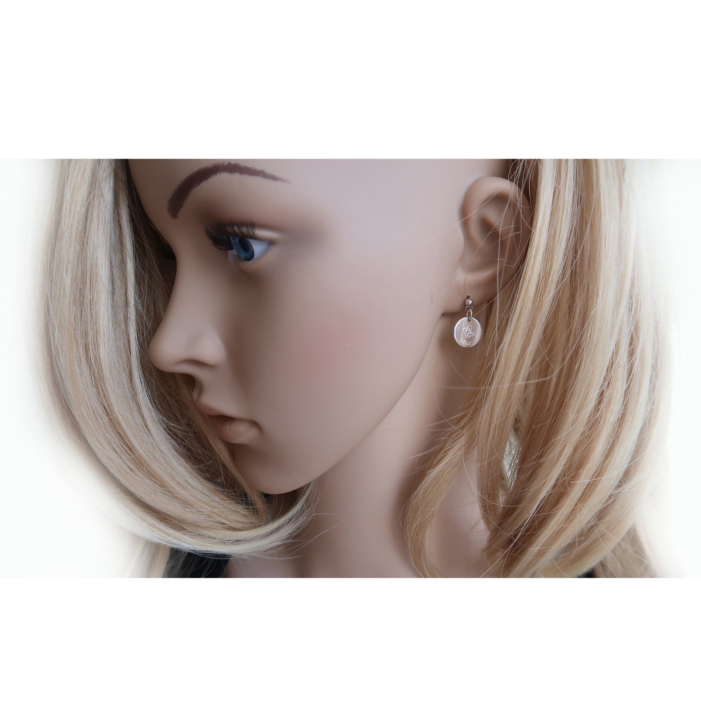 Eine Frau trägt Ohrringe mit Gravur