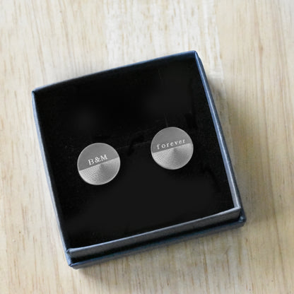 Runde Manschettenknöpfe aus Edelstahl mit matt gebürsteter Oberfläche, personalisierbar mit Wunschgravur, präsentiert in Geschenkbox.