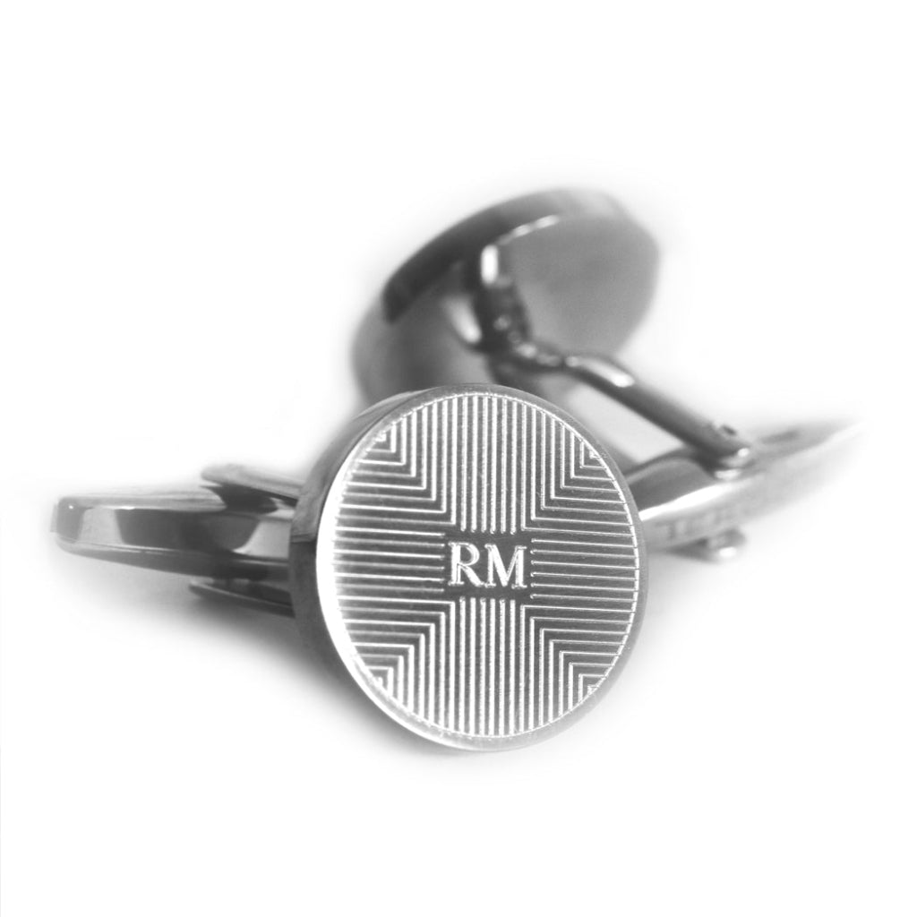 Runde, personalisierte Manschettenknöpfe, verziert mit einem geometrischen Muster sowie individueller Gravur.