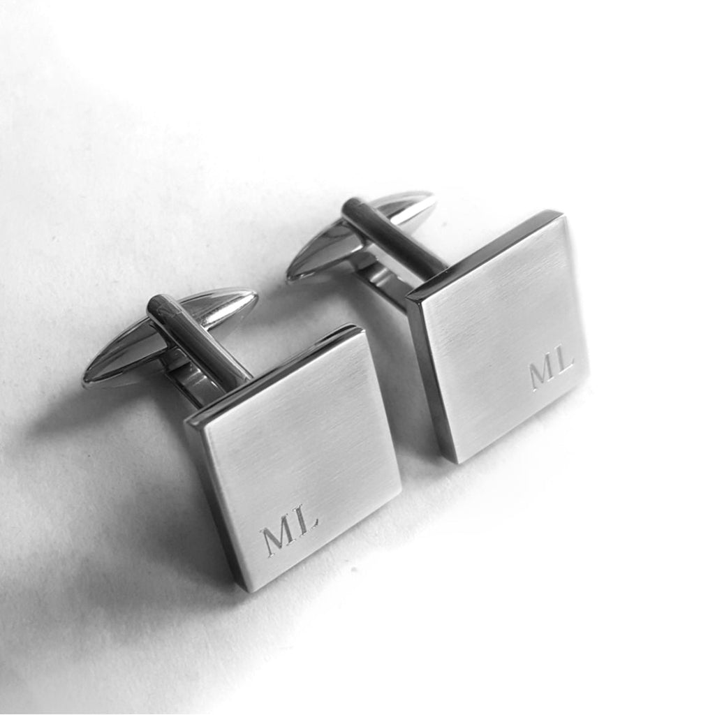 Quadratische Manschettenknöpfe mit Initialen am Rand (Blick von oben)