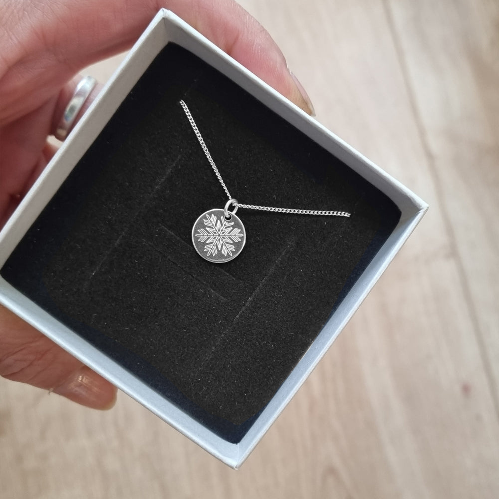 Silberner Schneeflocken Anhänger in einer Geschenkbox