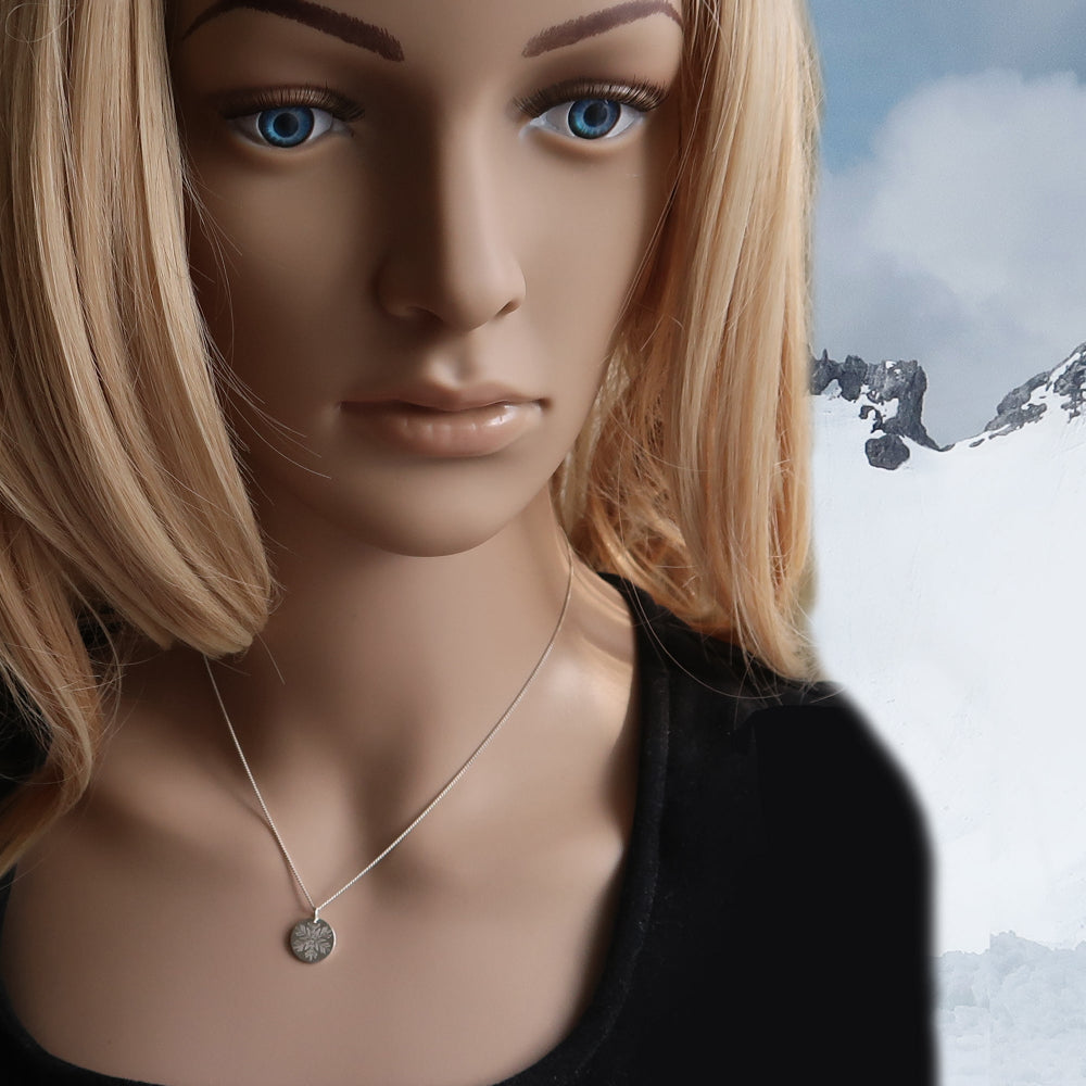 Frau trägt filigrane Schneeflocken Kette aus Silber vor winterlichem Hintergrund