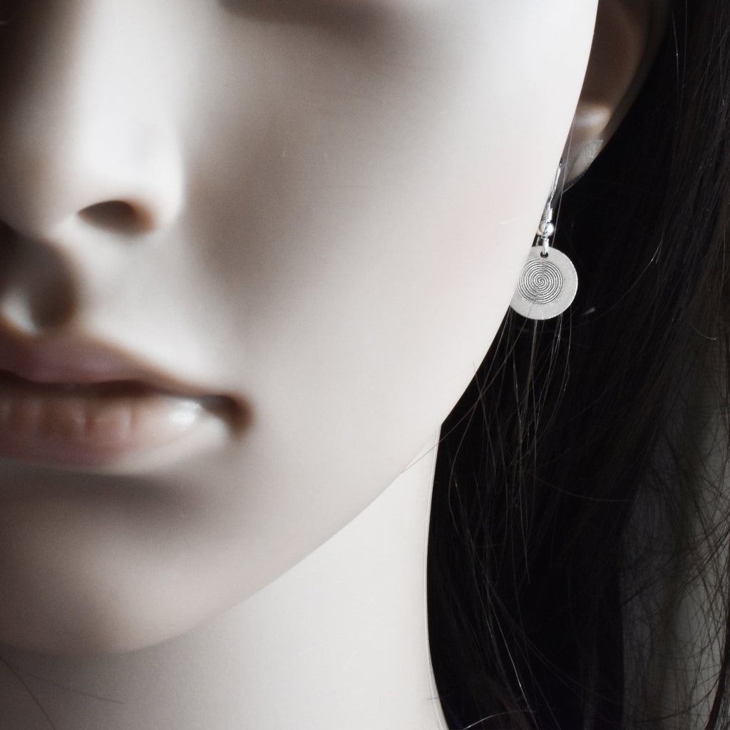 Elegante Silber Ohrhänger mit Spiralmotiv getragen