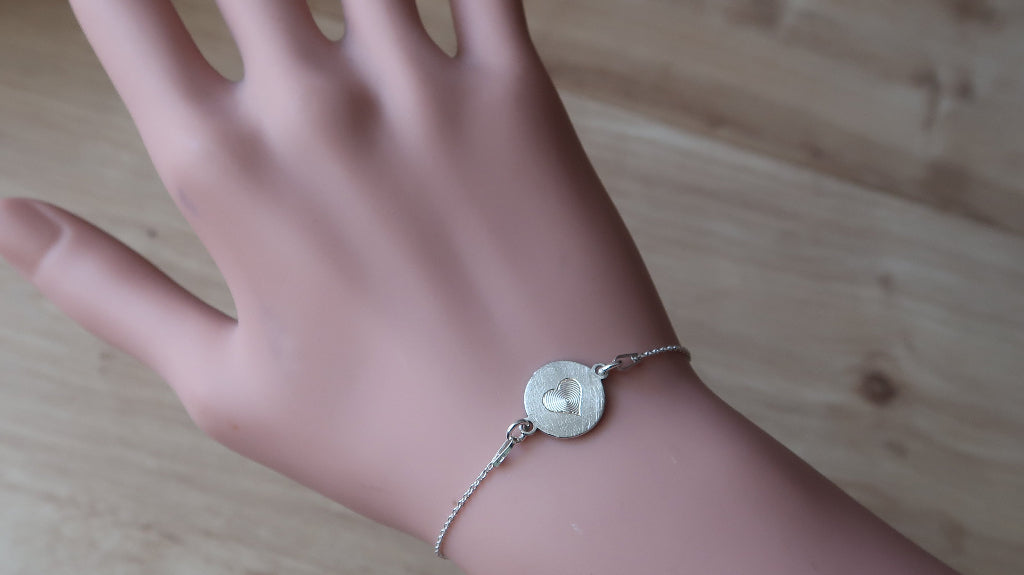 Silberarmband mit Herzmotiv am Handgelenk