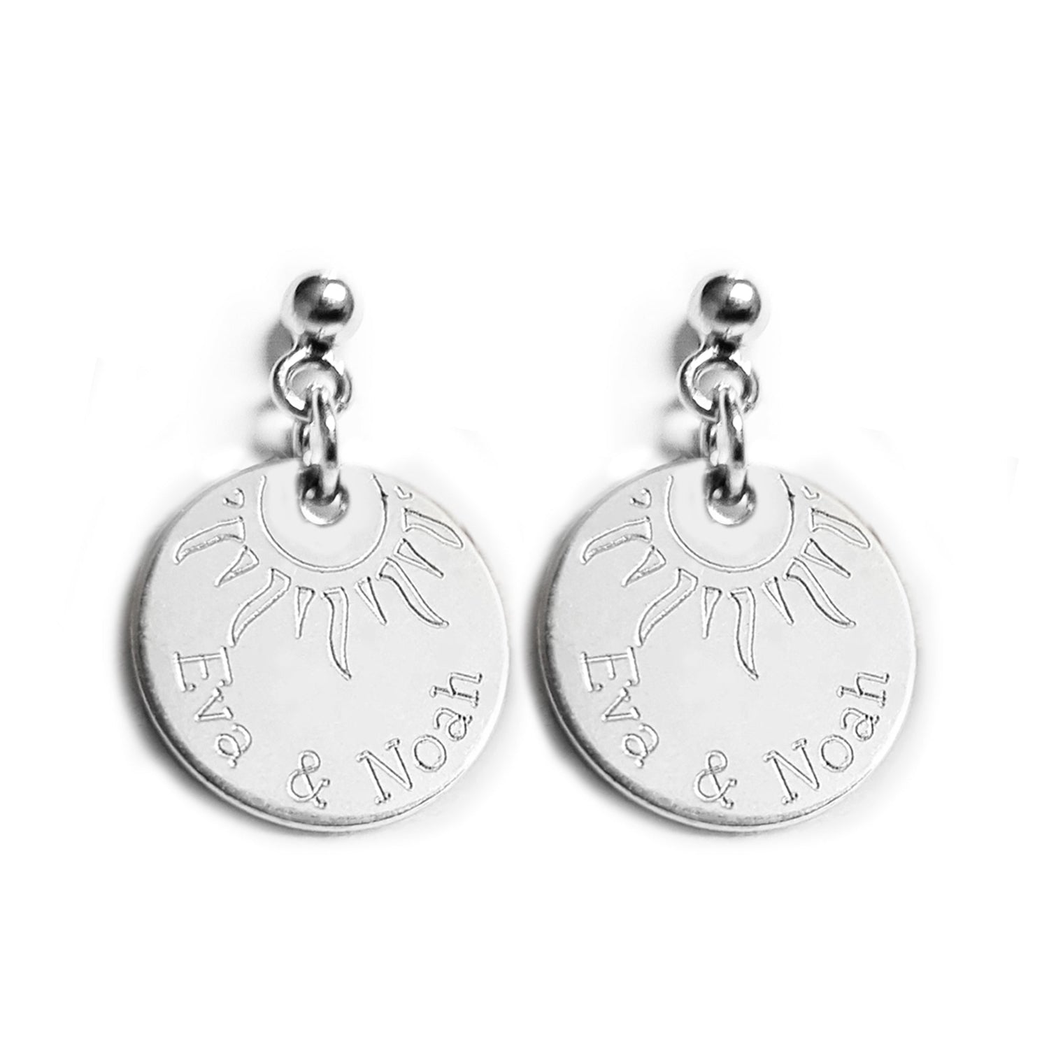 Silberohrringe mit zwei eingravierten Namen und einer halben Sonne.