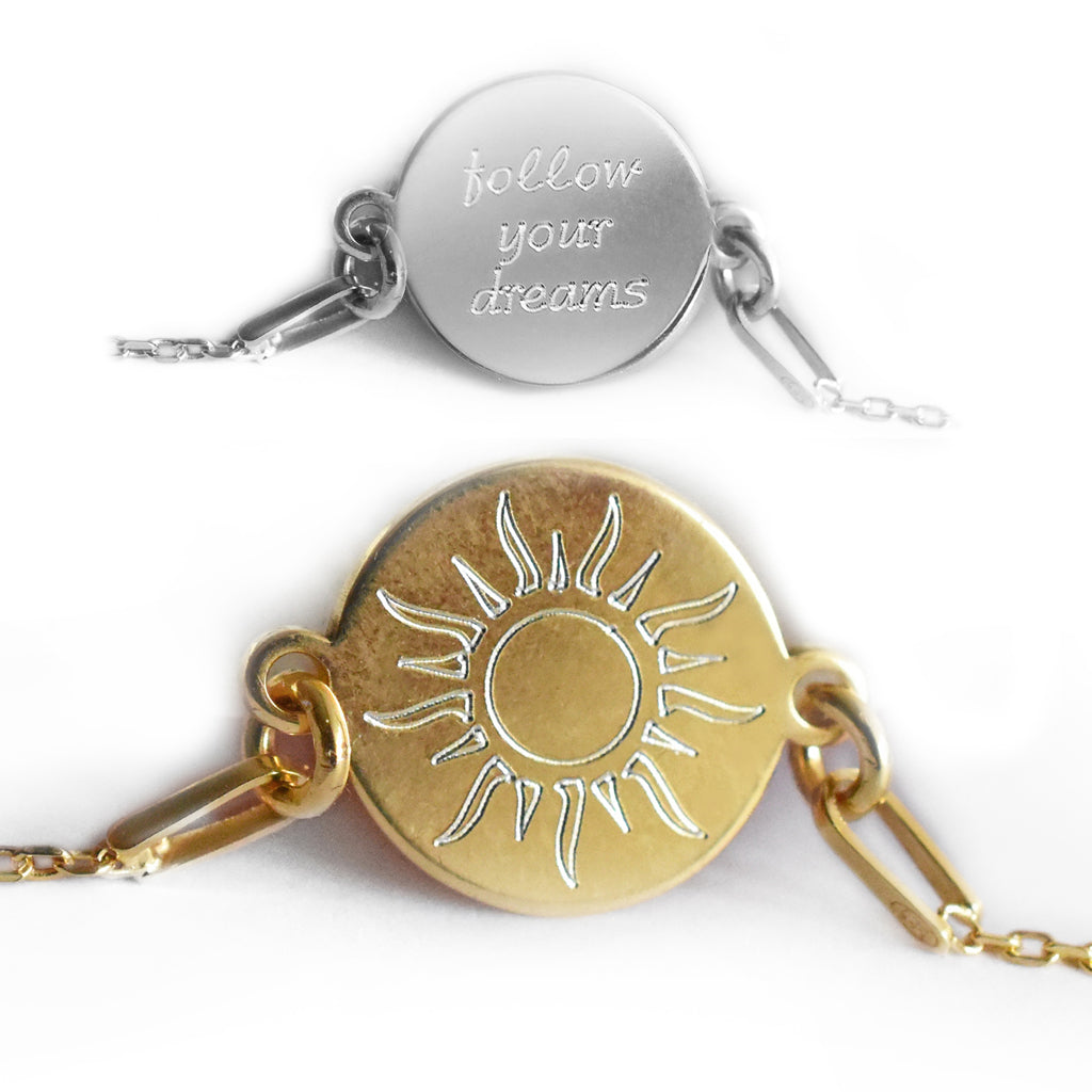 Zwei Armbänder: vorne vergoldet mit Sonnenmotiv, hinten ein Beispiel in Silber mit Gravur auf der Rückseite.