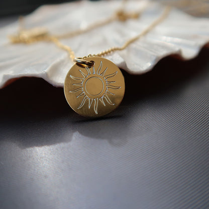 Zarte goldfarbene Halskette mit kleinem Sonnenanhänger im minimalistischen Design