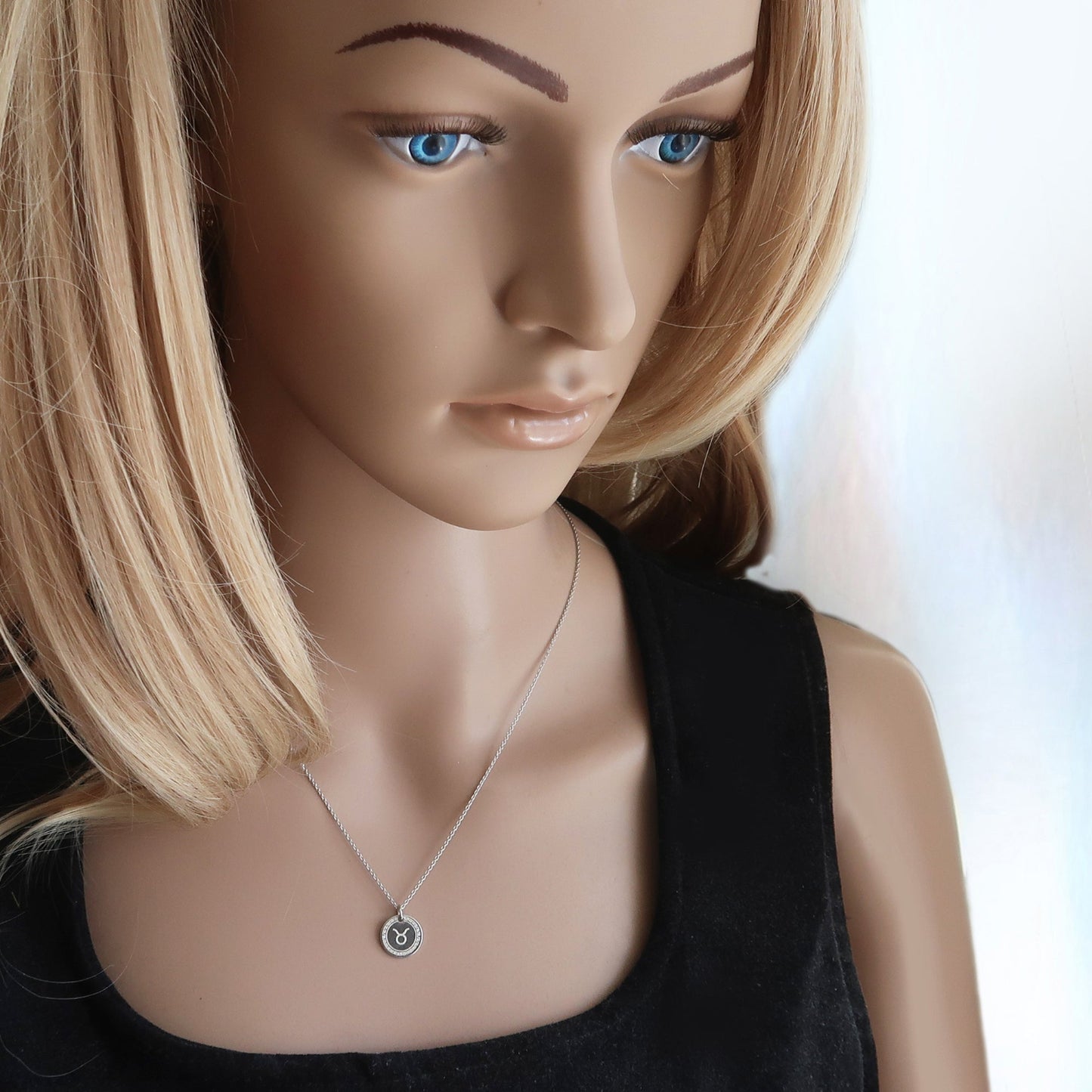 Junge Frau trägt filigrane Sternzeichenkette