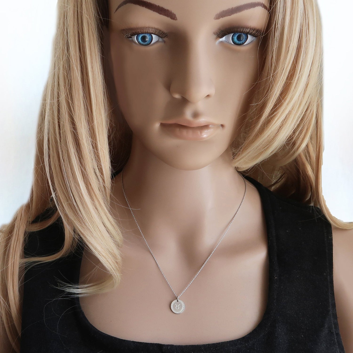 Eine Frau trägt kleine Sternzeichenkette