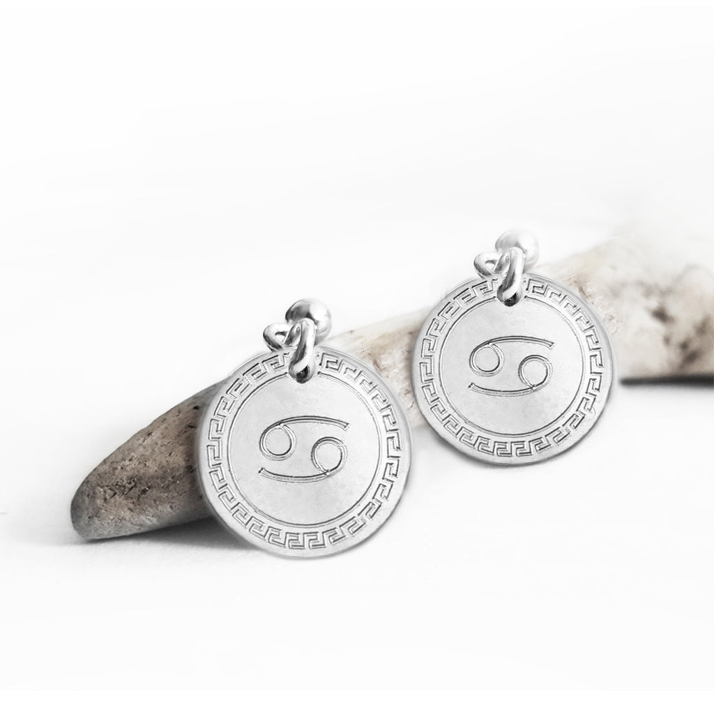 Detailaufnahme: runde Ohrringe aus Silber mit Sternzeichen