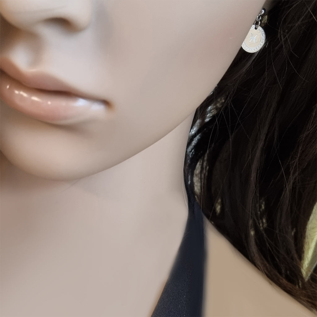 Runde Ohrringe mit Sternzeichen, getragen am Ohr – Modelaufnahme