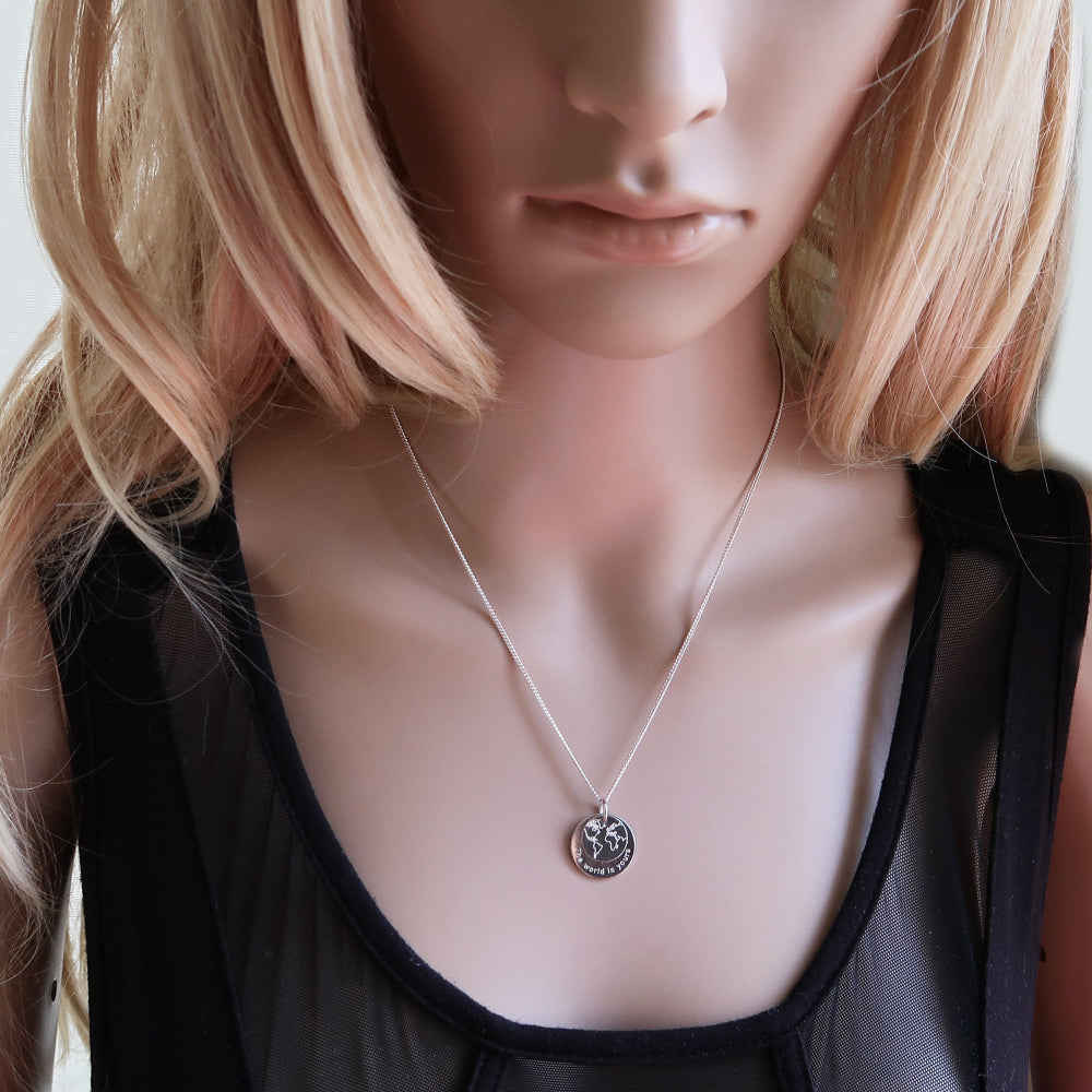 Frau trägt Silberkette:  Anhänger-Duo mit Weltkarte und Gravur