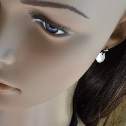 Runde Yin Yang Ohrringe aus 925er Silber am Ohr einer Frau präsentiert