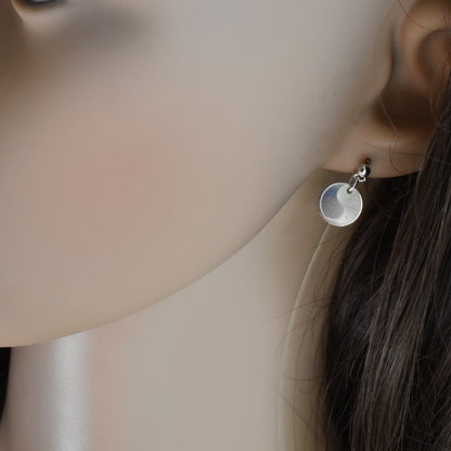 Yin Yang Ohrringe aus Silber am Ohr einer Frau 