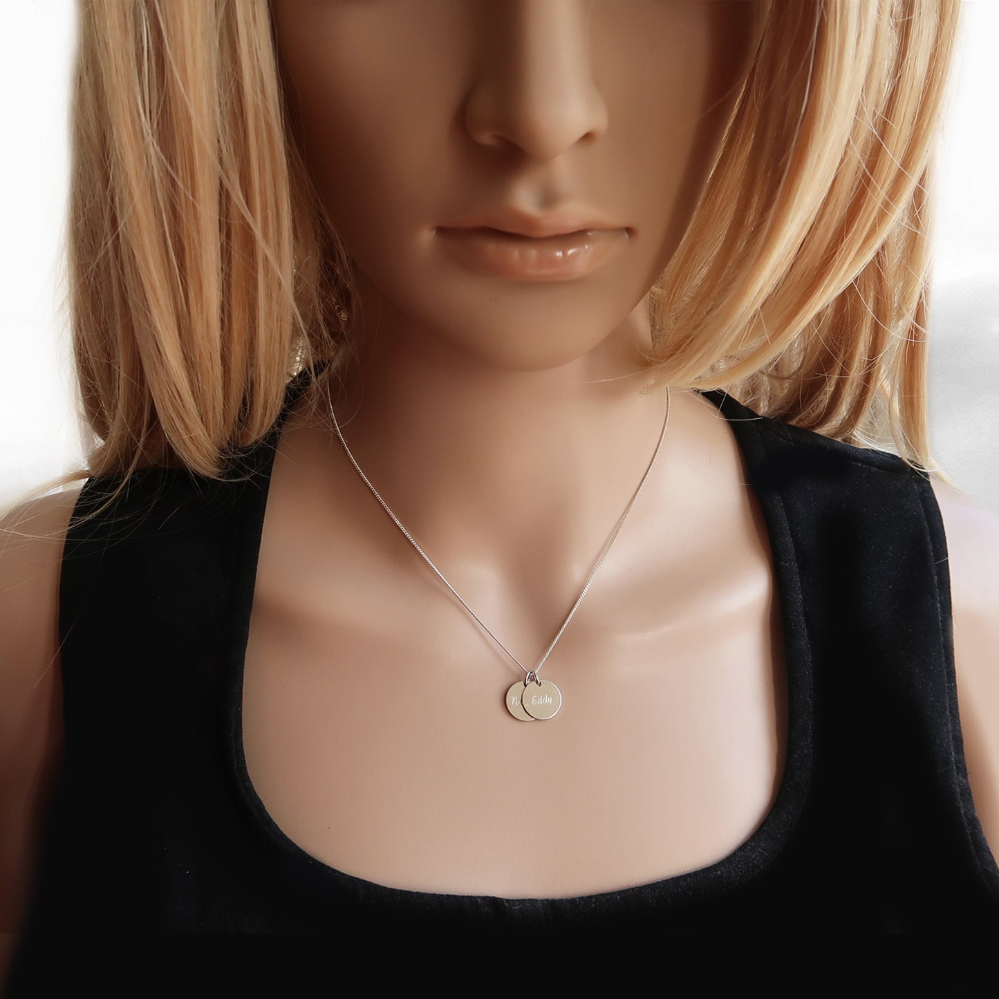 Silberkette mit zwei Anhängern am Hals einer Frau
