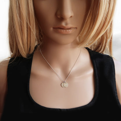 Silberkette mit zwei Anhängern am Hals einer Frau